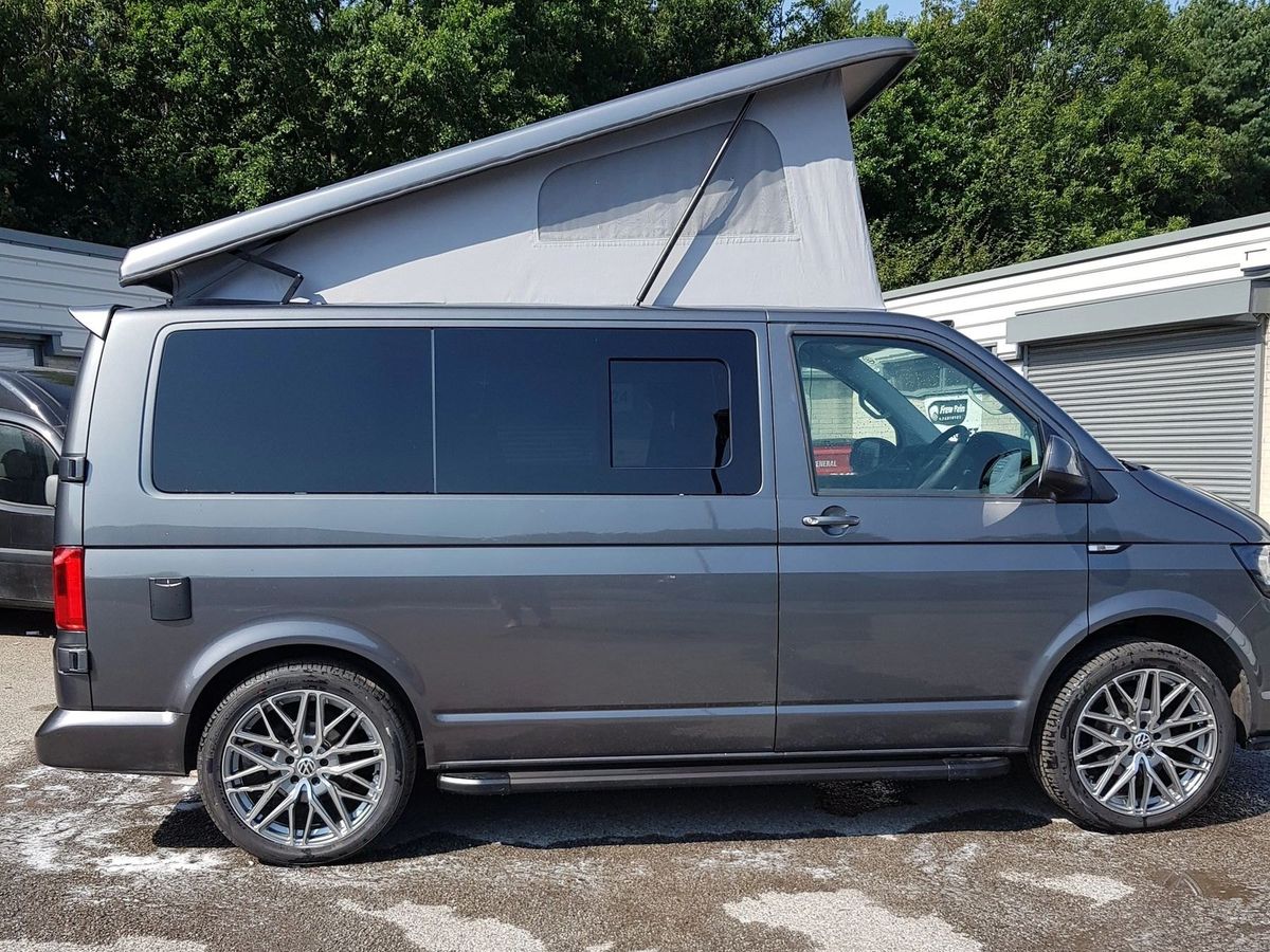 Grey VW Transporter T6 with an elevating roof, seen from the side