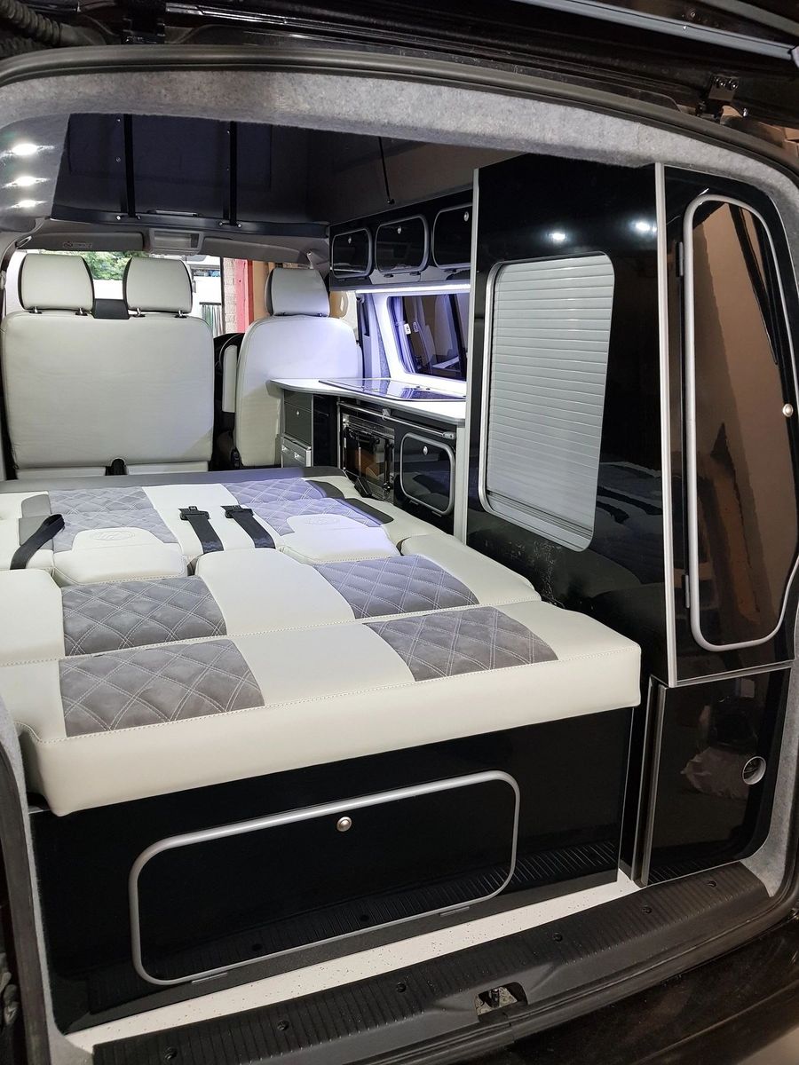 The bed made up flat, seen through the open tailgate